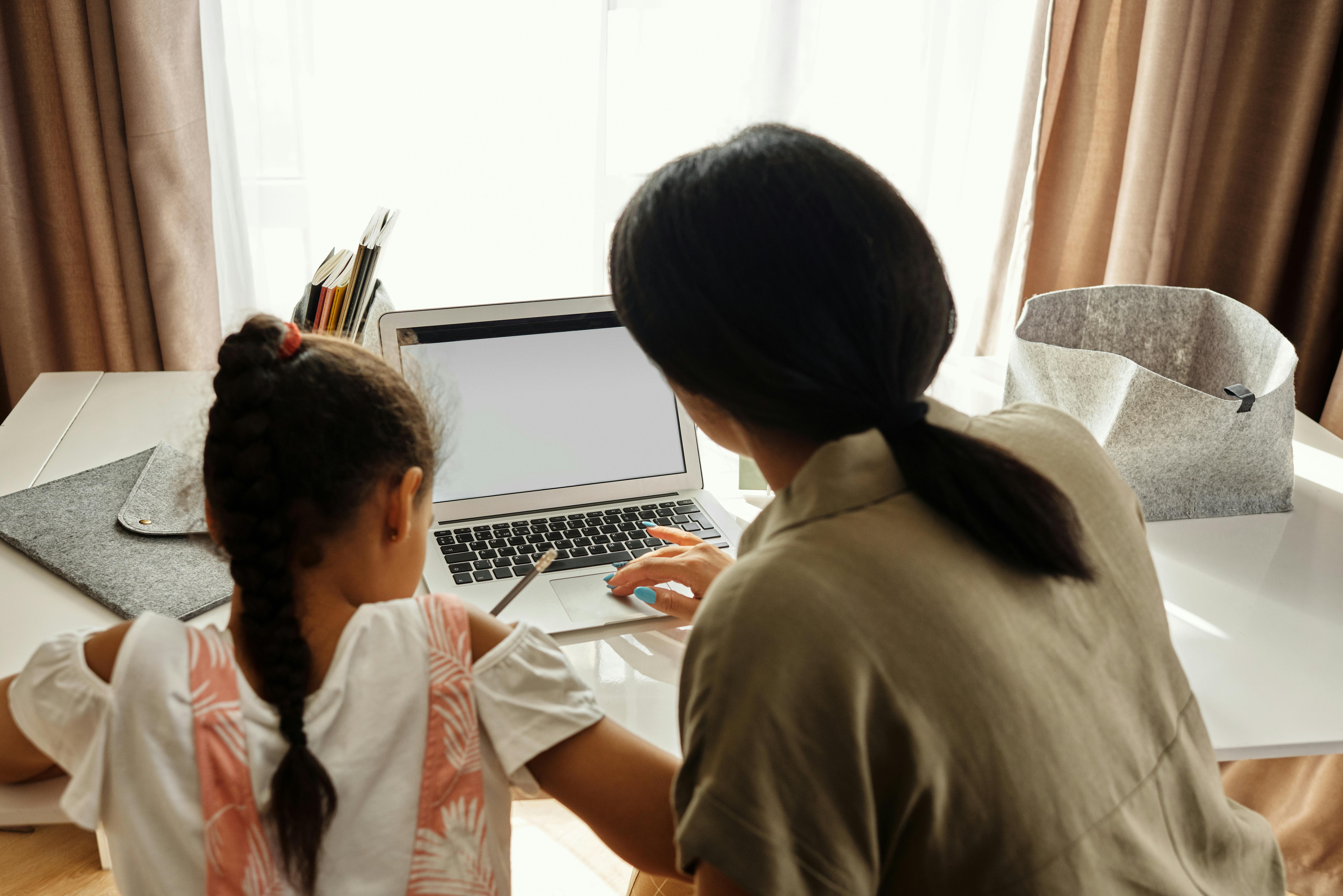 Parent and child working together at a laptop during an EmpowHERto program